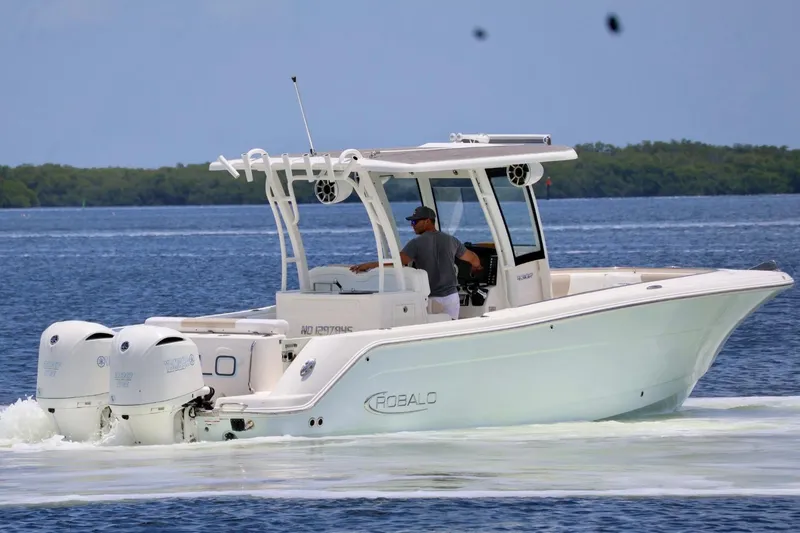 The Image of 2018 Robalo R302 Center Console boat cruising on a calm lake with dual engines. - 1