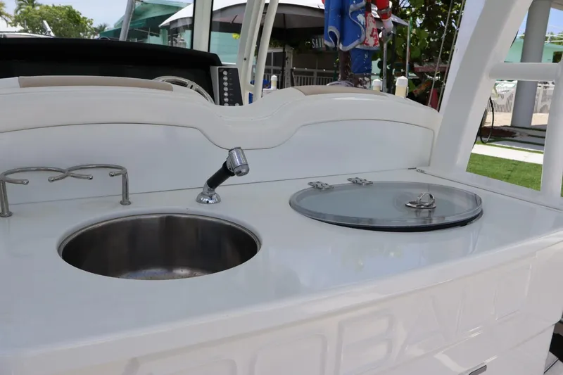 Slide: The Image of 2018 Robalo R302 Center Console boat sink and storage area. - 12