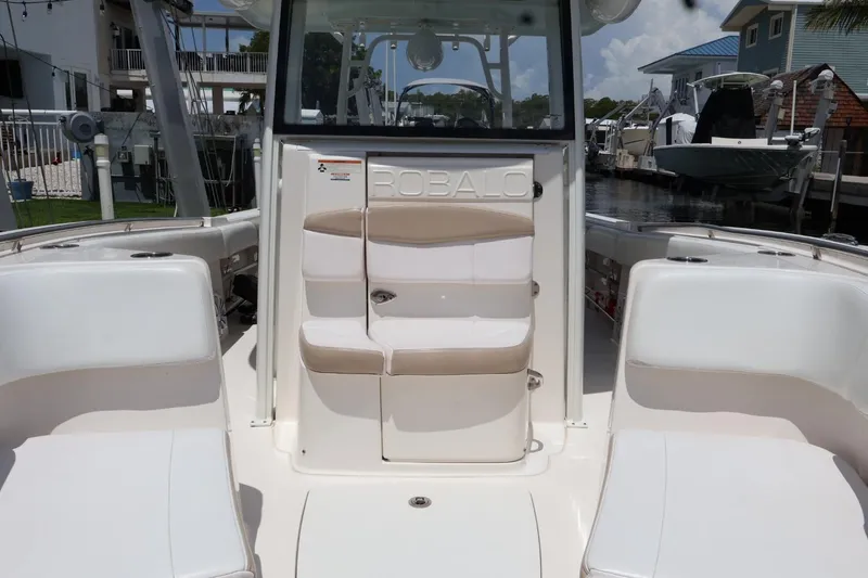 Slide: The Image of 2018 Robalo R302 Center Console boat interior with cushioned seating and console view. - 9