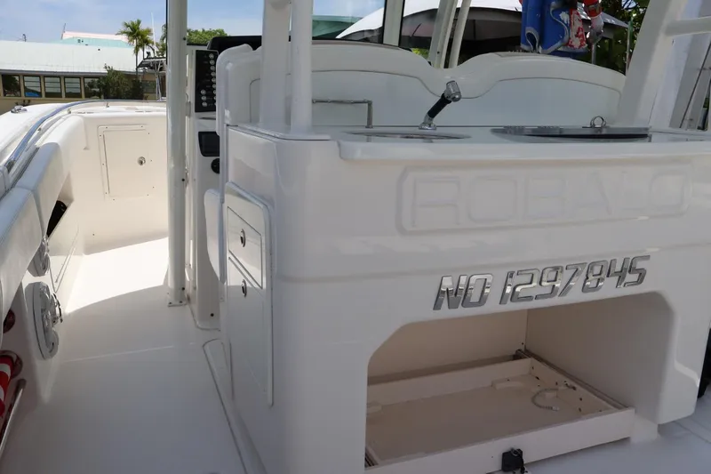 Slide: The Image of 2018 Robalo R302 Center Console boat interior with storage compartments and control panel. - 13