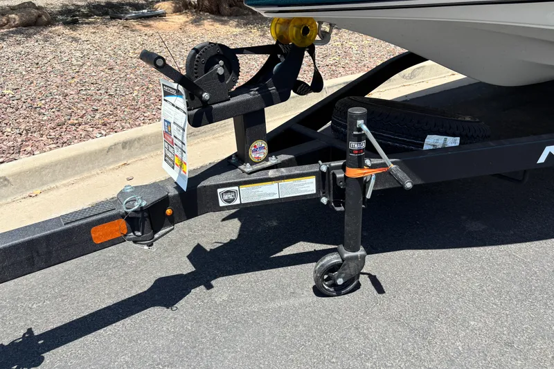 Slide: The Image of Trailer hitch and jack of a 2027 Nitro Z17 boat on pavement. - 2