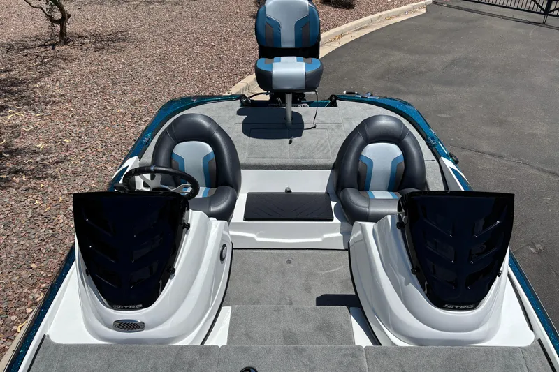 Slide: The Image of 2027 Nitro Z17 boat interior with dual seats and steering wheel, parked on pavement. - 7