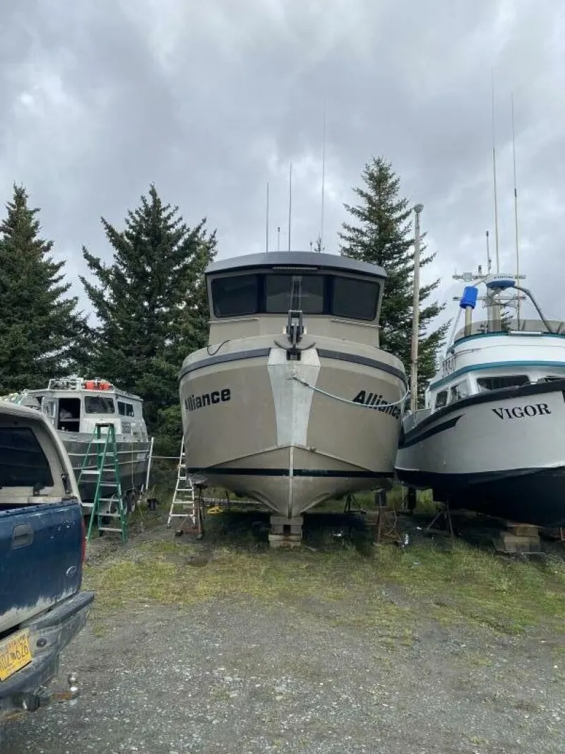 Slide: The Image of A 2022 Custom Freestyle Marine 32 boat is on a dry dock, surrounded by trees. - 32