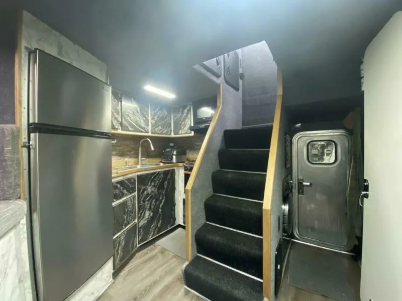 Slide: The Image of The interior view shows a modern kitchen with a fridge, sink, and stairs inside a boat. - 11