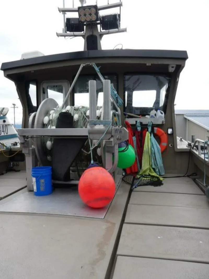 Slide: The Image of A sturdy boat with fishing nets and buoys on deck, ready for action. - 16