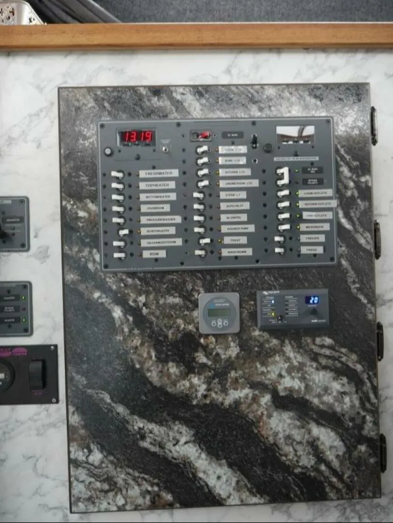 Slide: The Image of An electrical control panel on a boat with multiple switches and displays. - 26