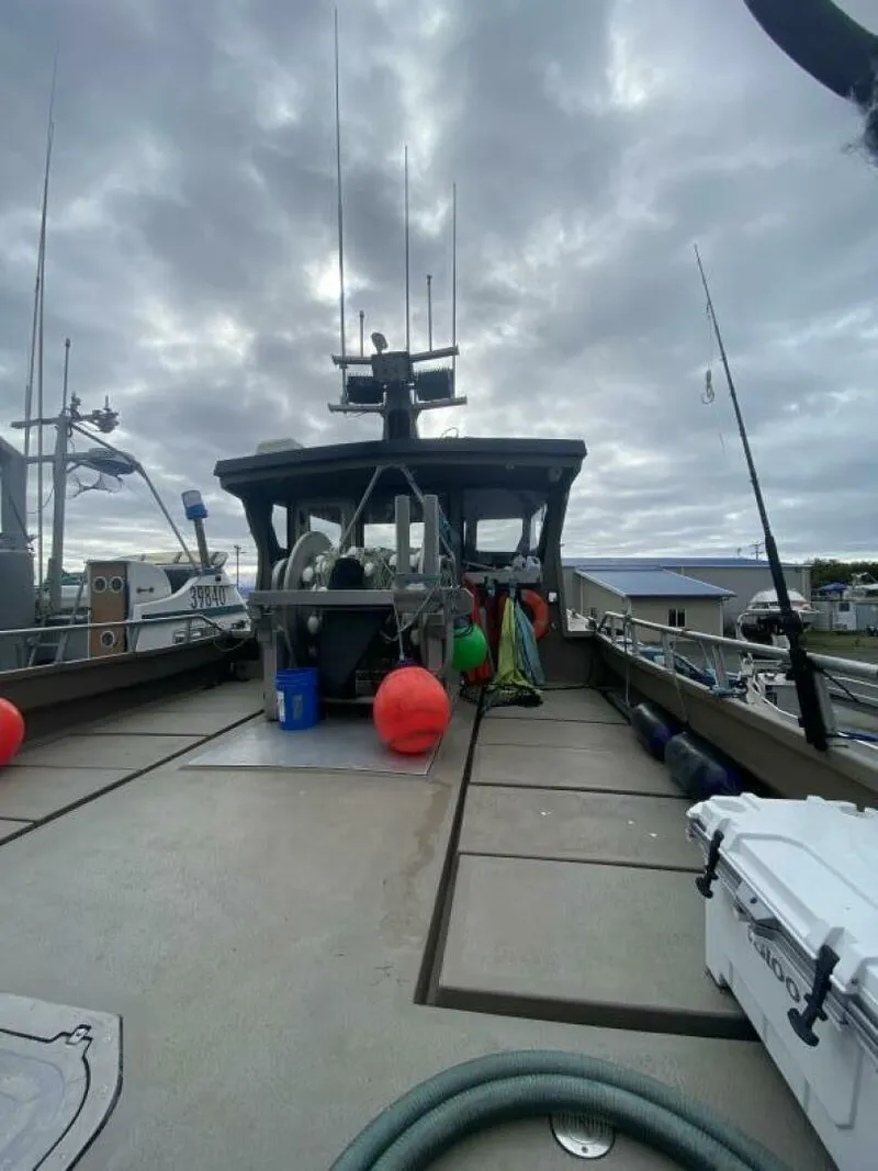 Slide: The Image of A sturdy boat with a cabin, antennas, and equipment on deck, under a cloudy sky. - 38