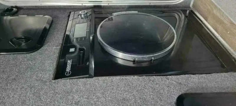 Slide: The Image of A modern cooktop with a round burner and controls, set into a gray countertop. - 18