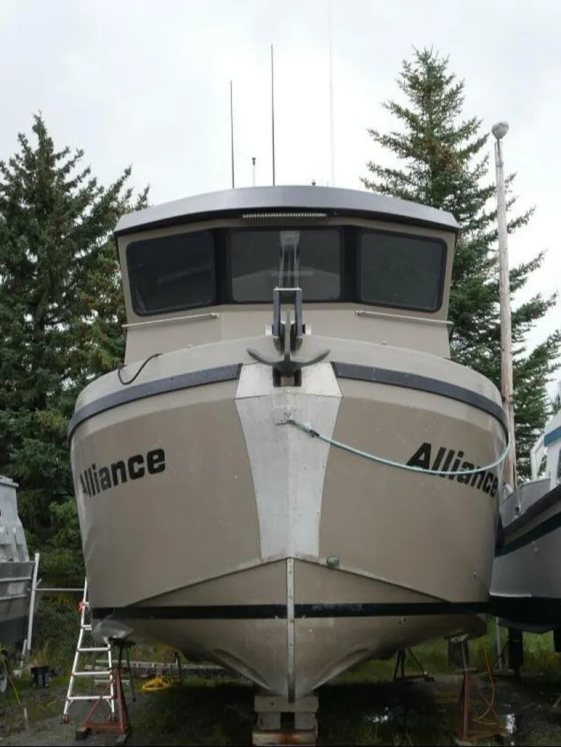 Slide: The Image of A modern boat named "Alliance" is on land, surrounded by trees. - 3