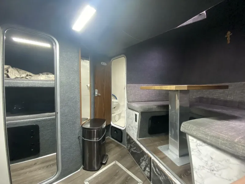 Slide: The Image of Interior of a modern yacht with seating area, table, and sleeping quarters. Sleek design with wood and fabric accents. - 40