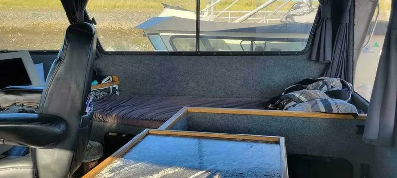 Slide: The Image of Boat interior with seating, table, and windows overlooking another boat. - 6
