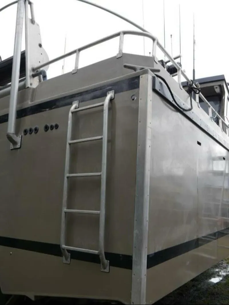 Slide: The Image of The image shows the stern of a Custom Freestyle Marine 32 boat with a ladder. - 8