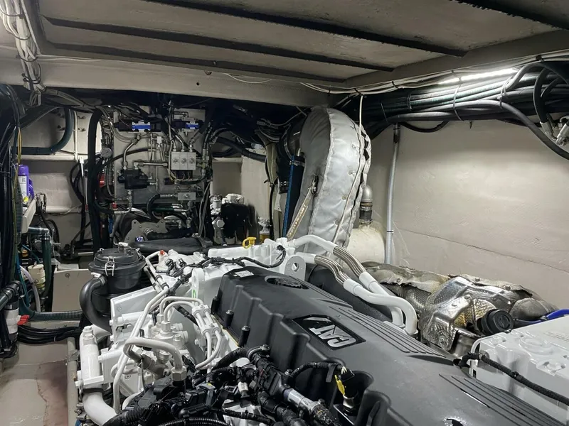Slide: The Image of The engine room of a 2022 Custom Freestyle Marine 32 boat features complex machinery and wiring. - 43