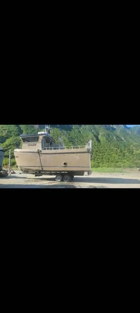 Slide: The Image of A 2022 Custom Freestyle Marine 32 boat on a trailer, set against a green mountainous backdrop. - 10