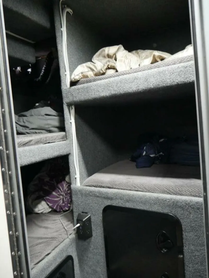 Slide: The Image of The image shows a compact cabin interior with multiple bunk beds and gray upholstery. - 30