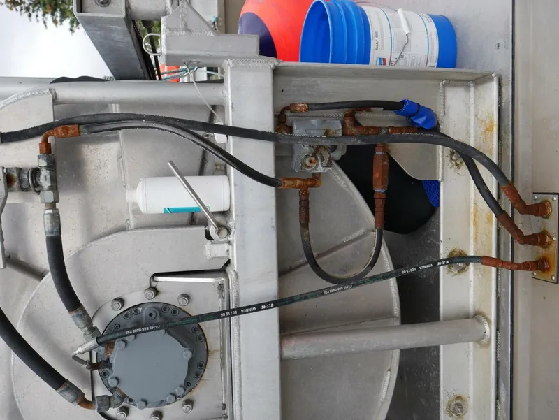 Slide: The Image of Close-up of hoses and pipes on a boat, with a blue and red bucket in the background. - 25