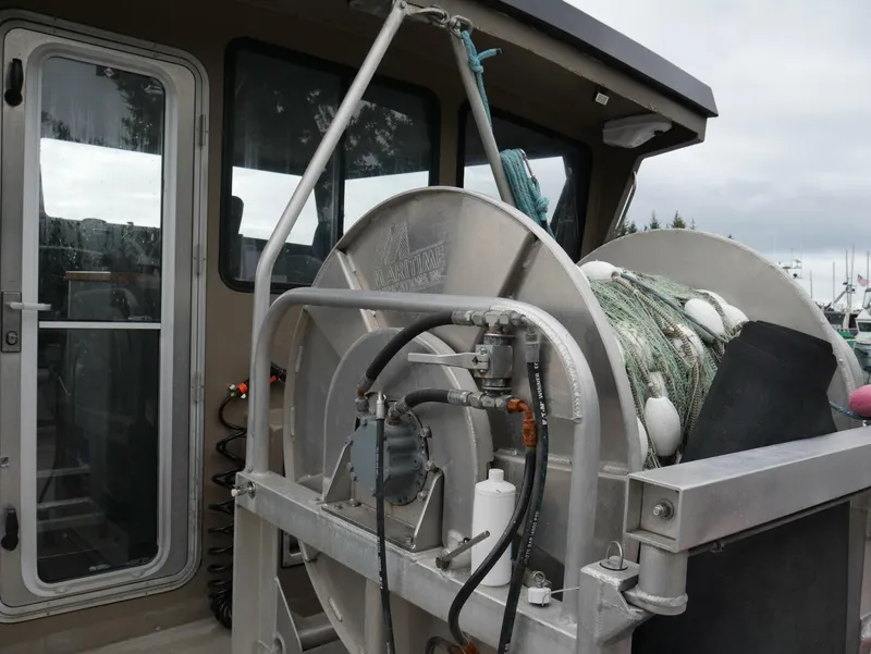 Slide: The Image of A fishing boat with a large winch and nets on deck, next to a cabin door. - 17