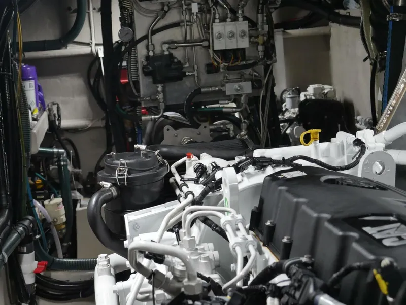 Slide: The Image of The engine room of a 2022 Custom Freestyle Marine 32 shows complex engine and wiring systems. - 29