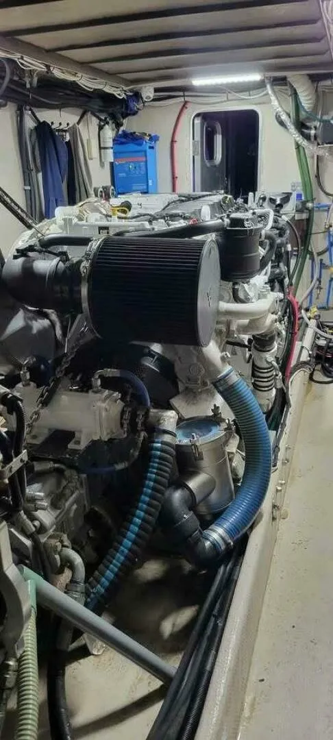 Slide: The Image of The engine room of a 2022 Custom Freestyle Marine 32 features a large engine with hoses. - 19