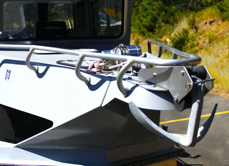 Slide: The Image of A gray boat with an anchor and ropes on the deck, surrounded by trees. - 14