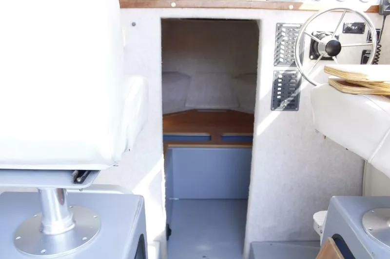 Slide: The Image of The image shows the interior of a boat with white seats and a helm station. - 45