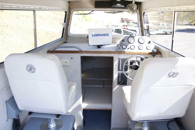 Slide: The Image of The image shows the cockpit of a 2005 ACB 27 boat with two white seats and a steering wheel. - 31