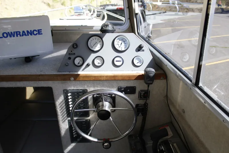 Slide: The Image of The image shows a boat cockpit with a steering wheel, gauges, and a radio. - 33