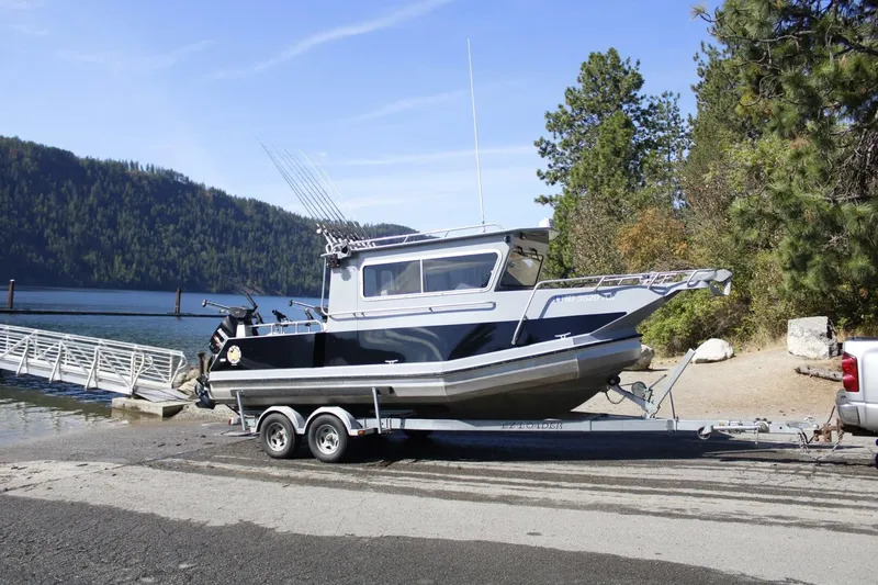 Slide: The Image of A 2005 ACB 27 boat on a trailer, ready to launch at a lakeside. - 6