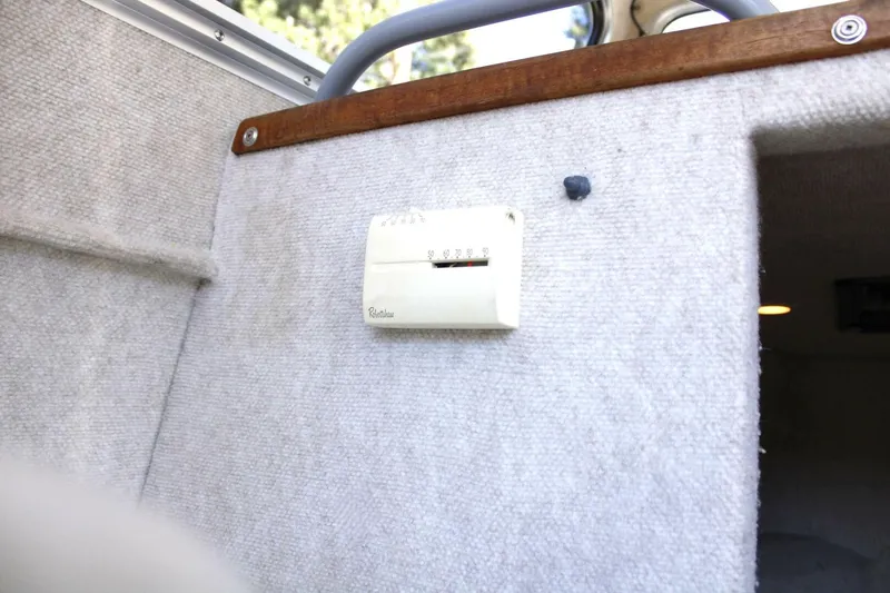 Slide: The Image of A thermostat is mounted on a carpeted wall inside a boat. - 48