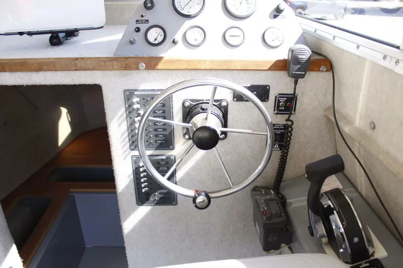 Slide: The Image of The image shows a boat's helm with a large steering wheel and various instruments. - 46