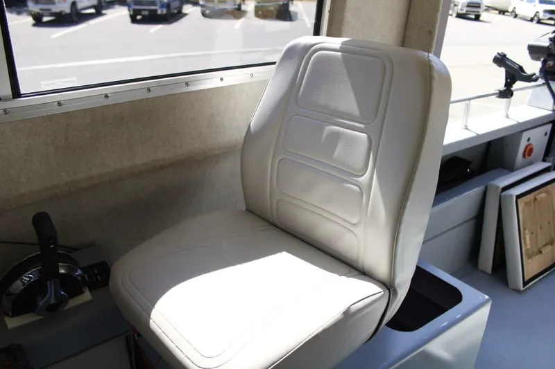 Slide: The Image of A beige captain's seat in a boat with a control lever beside it. - 34