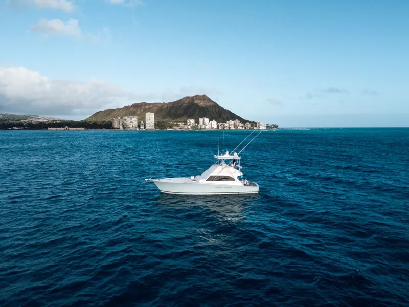 Slide: The Image of A white boat cruises on the open sea with an island in the background. - 27