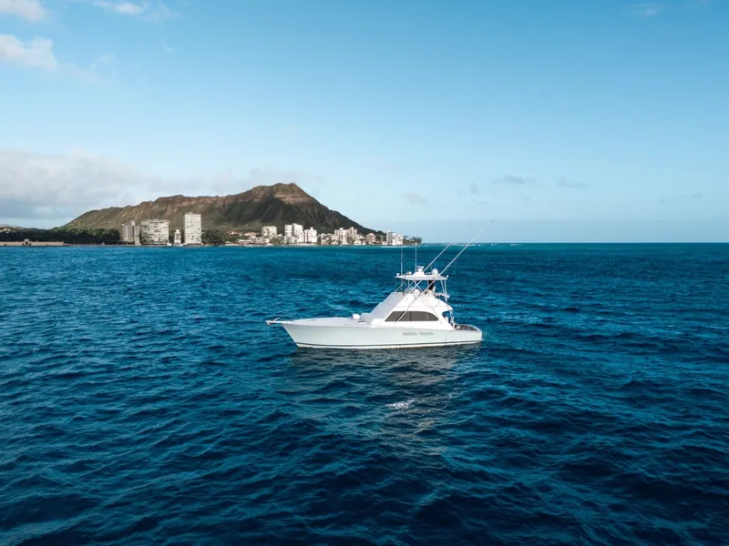 Slide: The Image of A 1998 Post 50 Convertible boat on open water with a coastline in the background. - 28