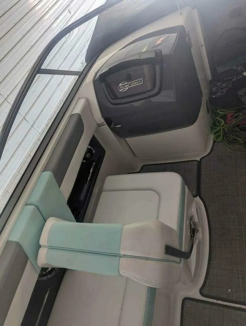 Slide: The Image of The image shows the interior of a 2021 Chaparral 230 Suncoast boat with seating and storage area. - 16