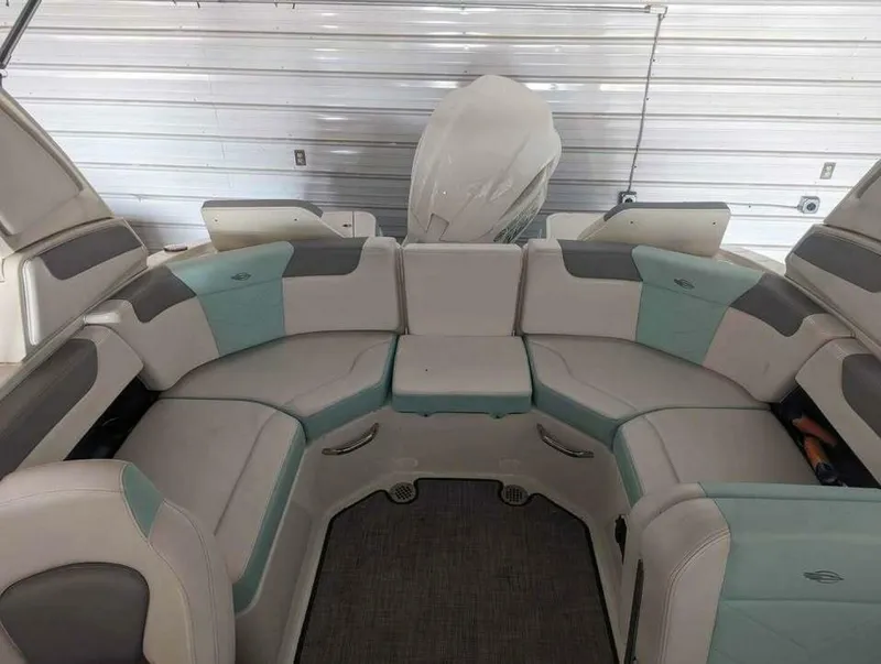 Slide: The Image of The image shows the seating area of a 2021 Chaparral 230 Suncoast boat. The upholstery is beige and turquoise. - 18