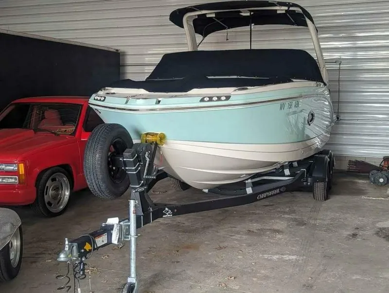 Slide: The Image of A 2021 Chaparral 230 Suncoast boat on a trailer in a garage. - 2