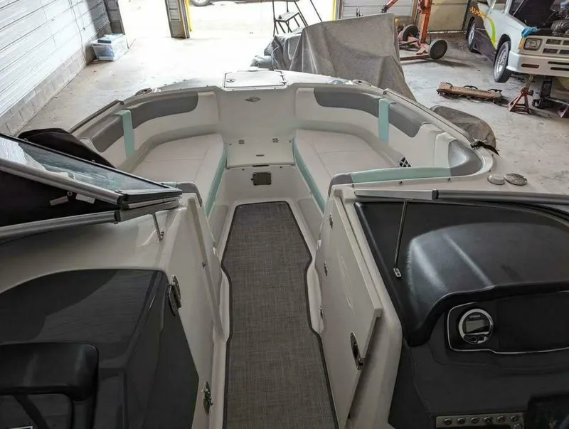 Slide: The Image of The image shows the cockpit of a 2021 Chaparral 230 Suncoast boat in a garage. - 6