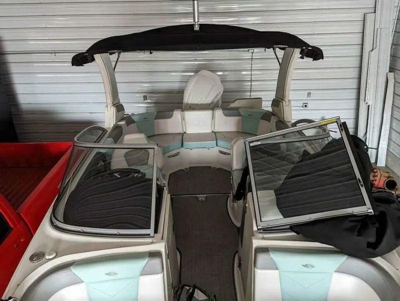 Slide: The Image of A 2021 Chaparral 230 Suncoast boat in a storage facility. It features an open cabin with seating. - 14