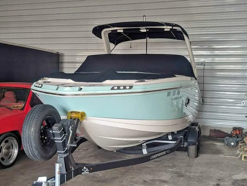 The Image of A 2021 Chaparral 230 Suncoast boat is on a trailer in a garage. - 0