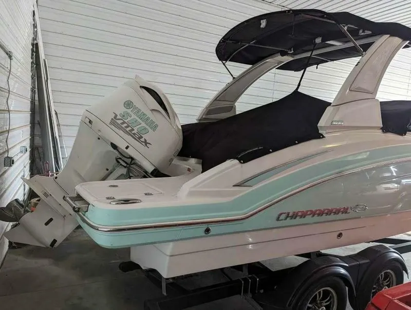 Slide: The Image of A 2021 Chaparral 230 Suncoast boat with a Yamaha outboard motor, parked in a storage facility. - 4