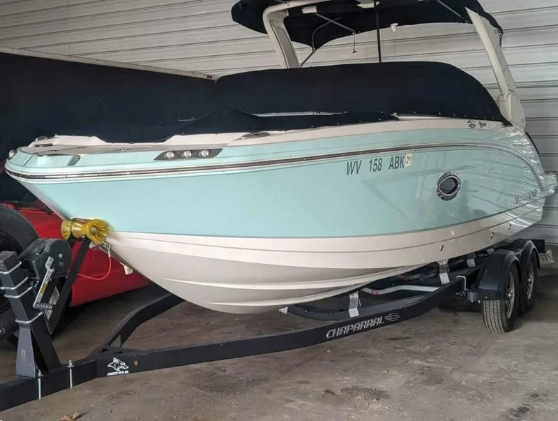 Slide: The Image of A 2021 Chaparral 230 Suncoast boat on a trailer in a garage. - 1
