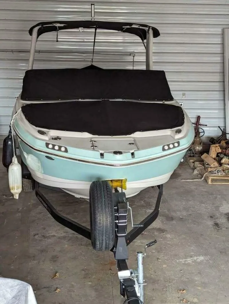 Slide: The Image of A 2021 Chaparral 230 Suncoast boat is in a garage, mounted on a trailer. - 3