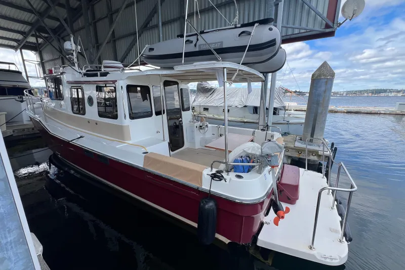 Slide: The Image of 2016 Ranger Tugs R-31 S docked in a marina, featuring a red and white exterior. - 4