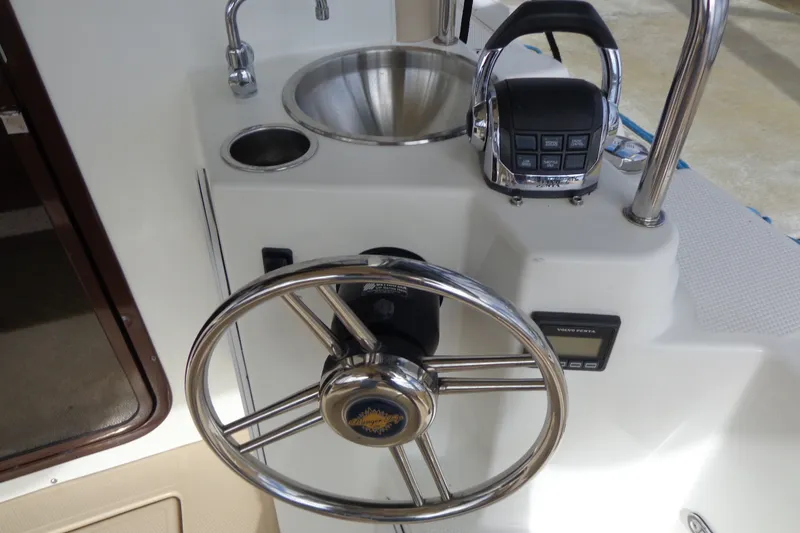 Slide: The Image of Steering wheel and controls of 2016 Ranger Tugs R-31 S boat, featuring a sink and throttle. - 9