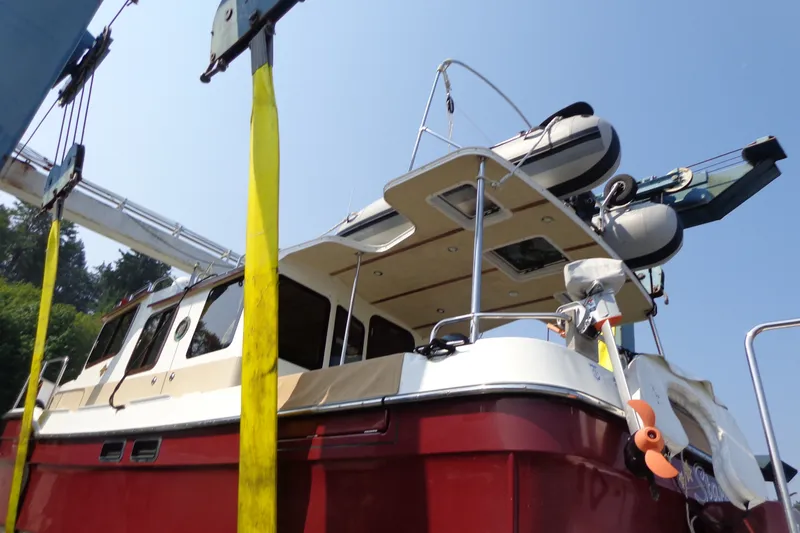 Slide: The Image of 2016 Ranger Tugs R-31 S boat on lift, featuring red hull and upper deck. - 73