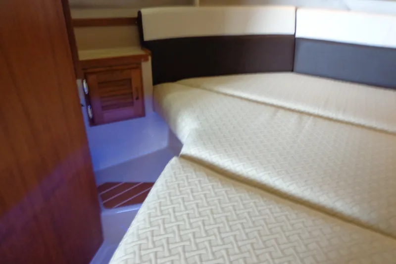 Slide: The Image of 2016 Ranger Tugs R-31 S cabin interior with bed and wooden cabinet. - 25