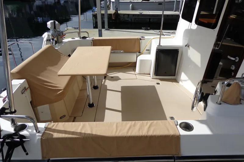Slide: The Image of 2016 Ranger Tugs R-31 S boat deck with seating and table, docked at marina. - 8
