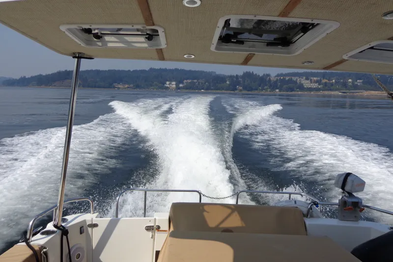 Slide: The Image of 2016 Ranger Tugs R-31 S cruising on a scenic lake, leaving a wake behind. - 78