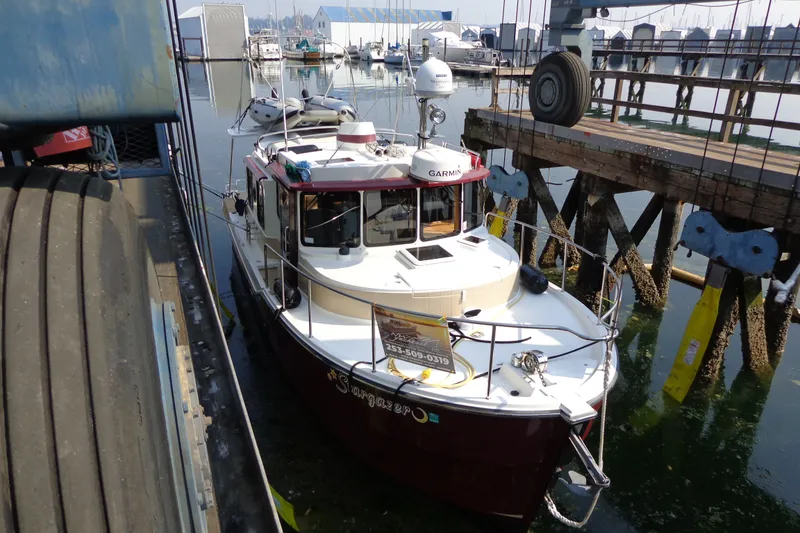 Slide: The Image of 2016 Ranger Tugs R-31 S docked at marina, surrounded by boats and equipment. - 70