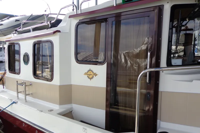 Slide: The Image of 2016 Ranger Tugs R-31 S boat exterior with windows and door, docked at marina. - 7